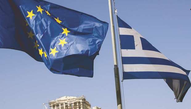 An EU flag (left) flies alongside a Greek national flag on Acropolis Hill in Athens (file). While Greeceu2019s crash rippled far beyond the borders of the country of just 11mn people, the effect at home was particularly dramatic. Economic output fell by a quarter and living standards collapsed after the loss of more than a million jobs pushed unemployment at one point to 28%.
