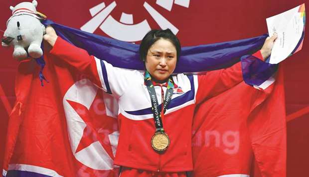 Gold medallist Ri Song-gum of North Korea celebrates on the podium for the womenu2019s 48kg weightlifting event in Jakarta yesterday. (AFP)