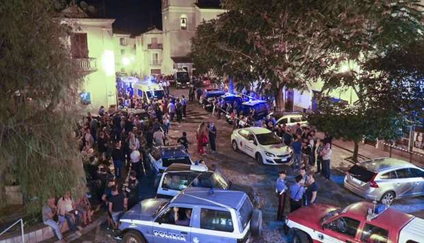 Rescuers and citizens wait in the central square of Civita, a village in the Italian Calabria southern region yesterday.