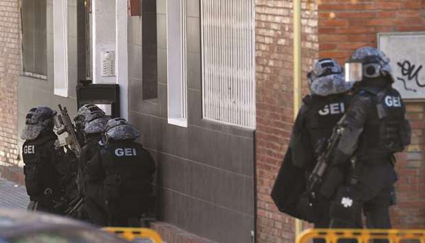 Special police forces personnel prepare to raid the apartment building of a man who tried to attack a police station in Cornella, near Barcelona.