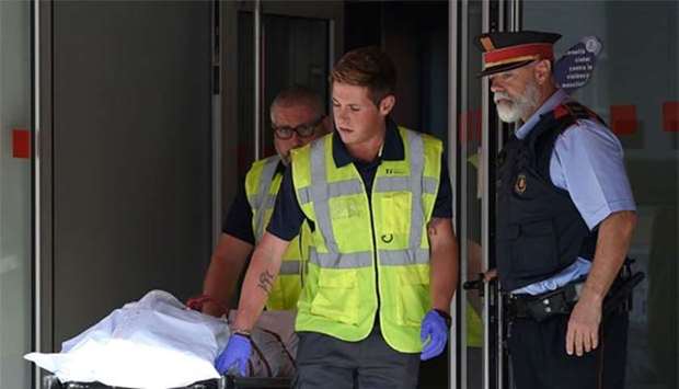 The body of a man who tried to attack a police station is carried out of the premises in Cornella near Barcelona on Monday.