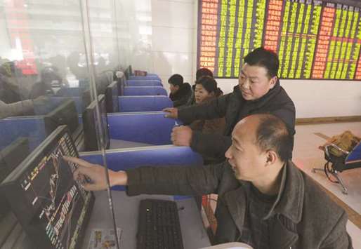 Investors talk as they look at a computer screen showing stock information at a brokerage house in Fuyang. The Composite closed up 1.3% to 2,733.83 points yesterday.