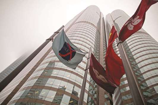 The flag of the Hong Kong Exchanges and Clearing (left) flies from a mast outside the stock exchange buildings in Hong Kong. Several Chinese automakers are among the worst performers in Hong Kongu2019s equity markets this year, and their slump may be far from over.