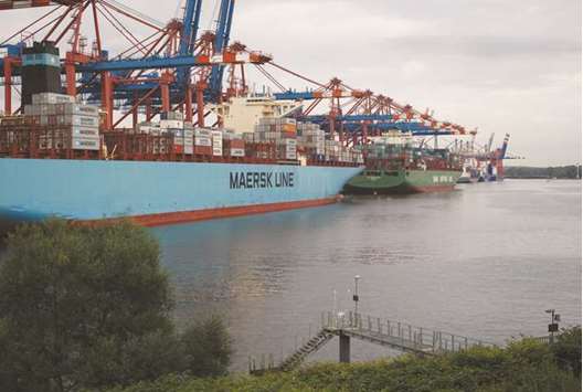 Shipping containers sit on a cargo vessel operated by AP Moeller-Maersk (left) on the dockside at the Eurogate Container Terminal in the Port of Hamburg (file). According to Danske Bank, Denmarku2019s biggest bank, Maersku2019s planned spin-off may have brought the worldu2019s biggest shipping company closer to a junk rating.