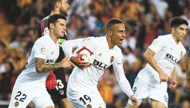 Valenciau2019s Rodrigo Moreno (centre) celebrates with teammates after scoring against Atletico Madrid in the La Liga at the Mestalla Stadium in Valencia. (AFP)