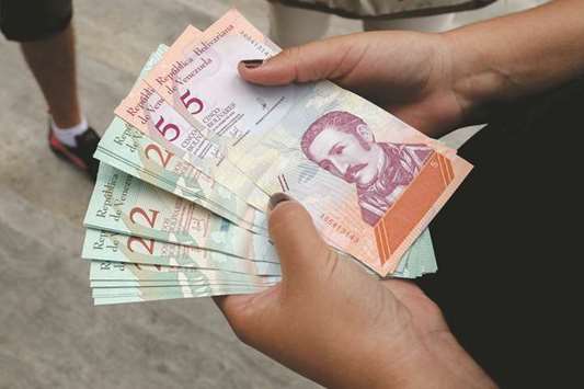 A woman holds new bolivar-notes in downtown Caracas.