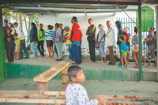 Venezuelans queue to eat breakfast at Spanish priest Jose Lopez Fernandez de Bobadillau2019s parish in Pacaraima, Roraima, Brazil, at the border, yesterday.