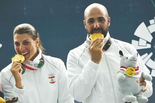 Gold medallists Lebanonu2019s Ray Bassil (left) and Alain Moussa pose for photographers during the podium ceremony for the trap mixed team shooting event yesterday. (AFP)