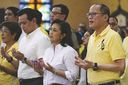 Former president Benigno Aquino along with current Vice President Leni Robredo pray during a mass commemorating the 35th death anniversary of Aquinou2019s father Ninoy in Manila, yesterday.