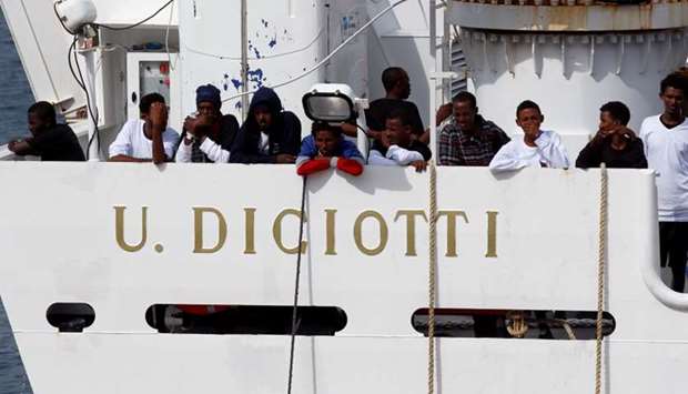 Migrants waits to disembark from Italian coast guard vessel ,Diciotti, as they arrive at the port of Catania, Italy, yesterday.