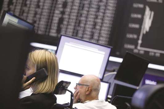 Traders monitor financial data inside the Frankfurt Stock Exchange. The DAX blue chip index closed 1.5% down at 12,546.33 points yesterday.