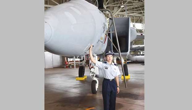 First Lieutenant Misa Matsushima of the Japan Air Self Defence Force poses beside an F-15J air superiority fighter at Nyutabaru airbase in the outskirts of Miyazaki, Miyazaki prefecture, Japan yesterday.