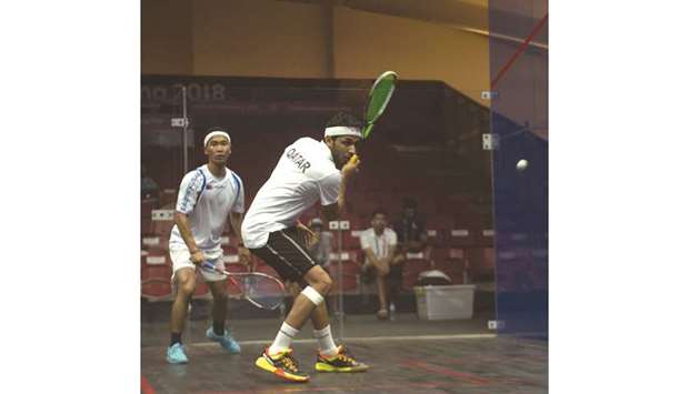 Qataru2019s Abdulla al-Tamimi (foreground) in action against Japanu2019s Tsukue Ryunosuke at the GBK Squash Stadium in Jakarta yesterday.