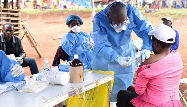 A Congolese health worker administers Ebola vaccine to a woman who had contact with an Ebola sufferer in the village of Mangina in North Kivu province of the Democratic Republic of Congo on August 18.