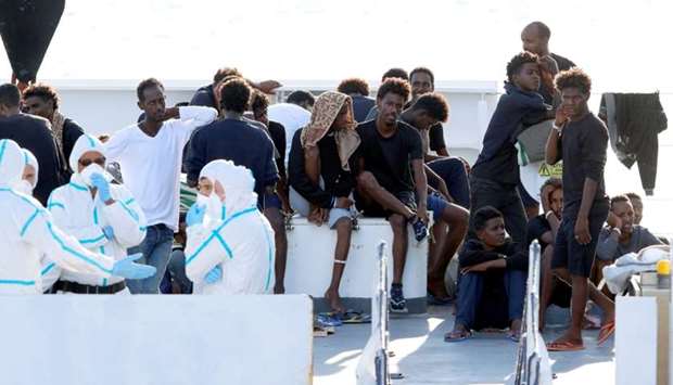 Migrants wait to disembark from the Italian coast guard vessel ,Diciotti, at the port of Catania on Wednesday.