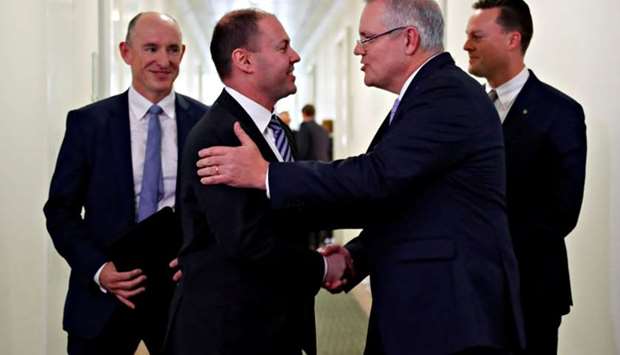 Incoming Australian Prime Minister Scott Morrison is congratulated by his new deputy Josh Frydenberg after a party meeting in Canberra.