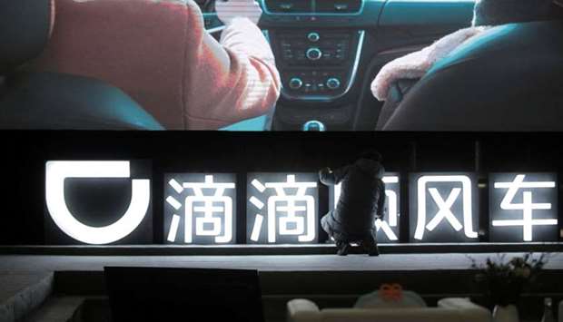 A man is seen in front of a Didi sign before a promotional event of its Hitch service for the Spring festival travel rush, in Beijing, China.  January 24, 2018 file photo.