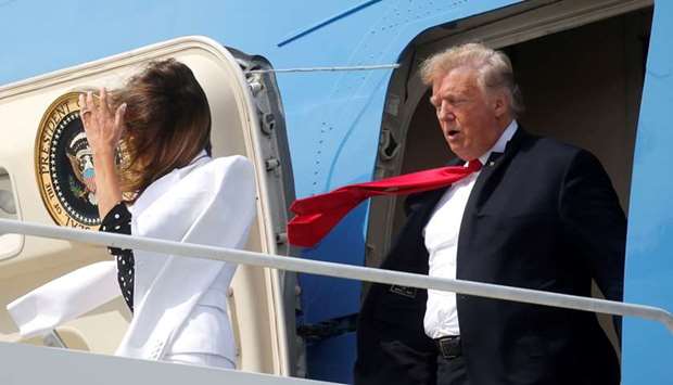 US President Donald Trump and first lady Melania Trump are buffeted by the wind as they emerge from Air Force One arriving in Columbus, Ohio, US.