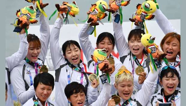 Members of the Unified Korea team celebrate with their bronze medals during a medal ceremony for the women's canoe 200m traditional boat race at the 2018 Asian Games in Palembang.
