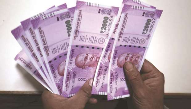 A bank executive counts new 2000 Indian rupee notes at a bank in Srinagar. The Reserve Bank of India, which intervened actively until the rupee hit 69 per dollar, has mostly stayed on the sidelines after the currency broke past the 70 psychological mark last week, according to foreign-exchange traders.