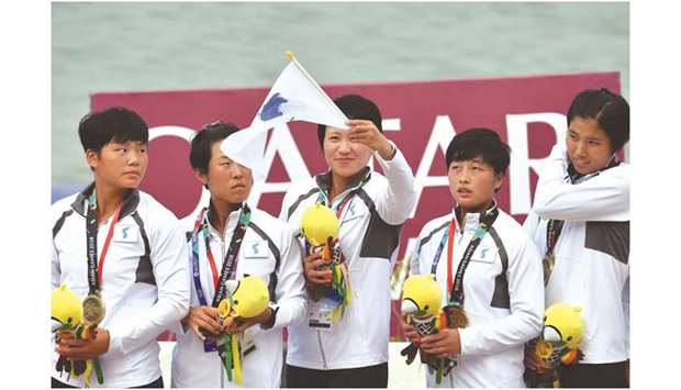 Members of the Unified Korea team celebrate with their bronze medals during the podium ceremony for the womenu2019s 200m traditional boat race at the Asian Games yesterday. (AFP)