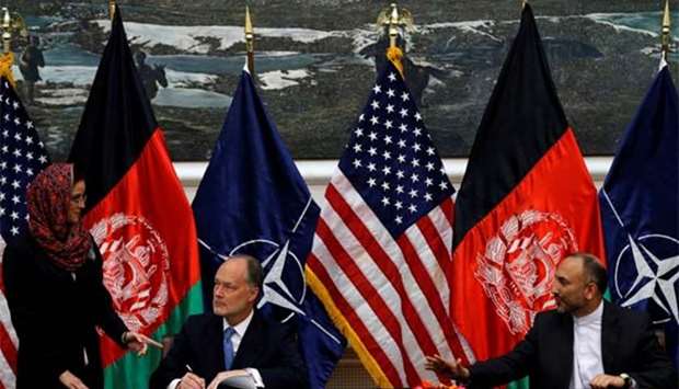 Afghan national security adviser Hanif Atmar (right) and US Ambassador James Cunningham sign a bilateral security agreement in Kabul in this file picture dated September 30, 2014.