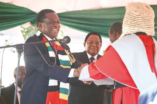 Zimbabwe President Emmerson Mnangagwa (left) takes his oath of office with the Chief Justice Luke Malaba (right) in Harare yesterday.