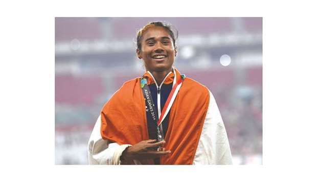 Silver medallist Indiau2019s Hima Das celebrates during the podium ceremony for the womenu2019s 400m event at the 2018 Asian Games in Jakarta yesterday. (AFP)