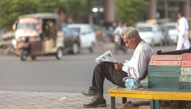 A man reads a newspaper while sitting on a bench at the side of a road in  Karachi (file). Pakistanu2019s budget deficit has widened to a whopping Rs2.26tn or 6.6% of gross domestic product in the outgoing fiscal year (2017-18).