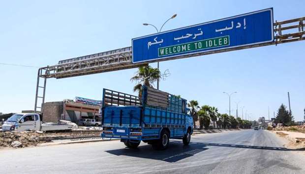 A truck drives past underneath a sign along the highway leading to the rebel-held northern Syrian city of Idlib.  Turkey is concerned about a planned Syrian government offensive against rebels in Idlib near the Turkish border. August 25, 2018 file picture. AFP