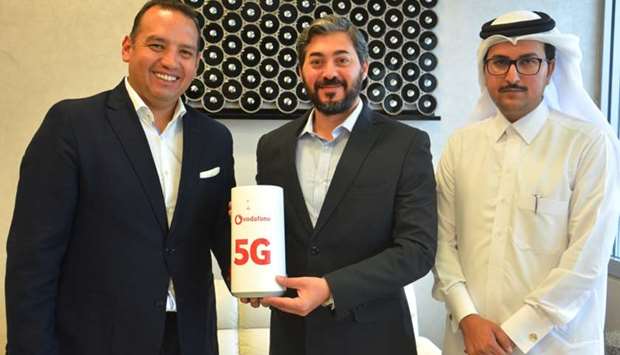 Vodafone Qatar COO Diego Camberos hands over the CPE to Gulf Bridge International officials.