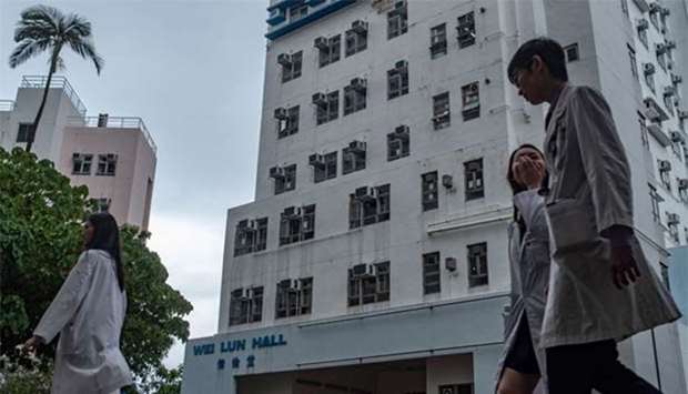 Students walk in front of University of Hong Kong's Wei Lun Hall, the residential block where professor Cheung Kie-chung and his family lived, in Hong Kong's Pok Fu Lam area on Wednesday.