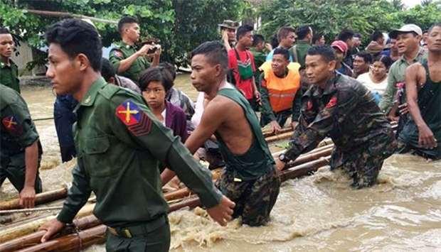 People are evacuated by Myanmar soldiers after flooding in Swar township on Wednesday.