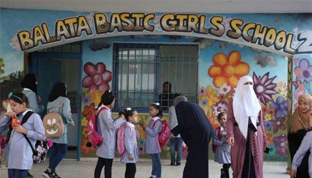 Pupils and teachers gather in front of a school run by United Nations agency for Palestinian refugees (UNRWA) in Balata refugee camp, east of Nablus in West Bank, on Wednesday.