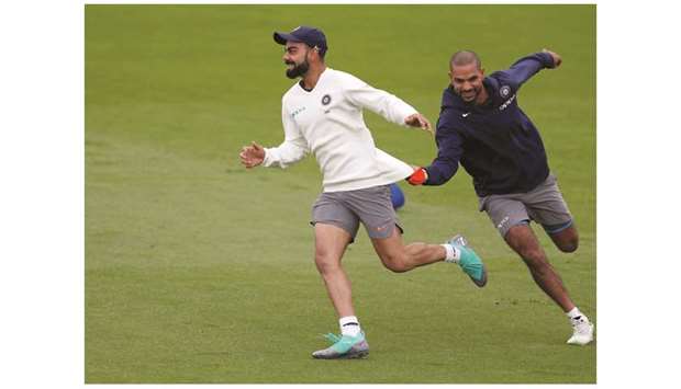 Indiau2019s captain Virat Kohli (left) and Shikhar Dhawan share a light  moment during a practice session in Southampton yesterday. (Reuters)