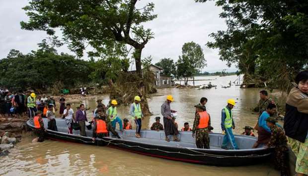 Myanmar soldiers use a boat to help residents cross a flooded area in Swar town of Bago region. 