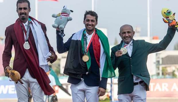 Qatar's silver medallist Sheikh Ali bin Khalid Al-Thani  (L), gold medallist from Kuwait Ali Alkhorafi (C) and bronze medaillist from Saudi Arabia Ramzy Hamad Alduhami attend the medal ceremony for the individual final round jumping event at the equestrian competition.