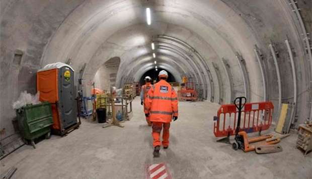 Workers walk through a tunnel during construction on the platform level of the new Crossrail section of Farringdon station in London. File picture