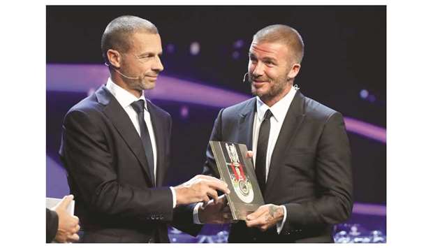 UEFA president Aleksander Ceferin (left) presents David Beckham with the UEFA Presidentu2019s Award on the sidelines of the Champions League group stage draw at the Grimaldi Forum in Monaco yesterday. (Reuters)