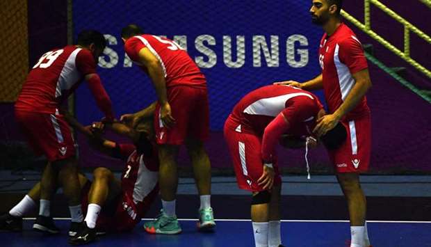 Bahrain's players rest after the match during the men's handball men's gold medal match between Qatar and Bahrain at the 2018 Asian Games in Jakarta.