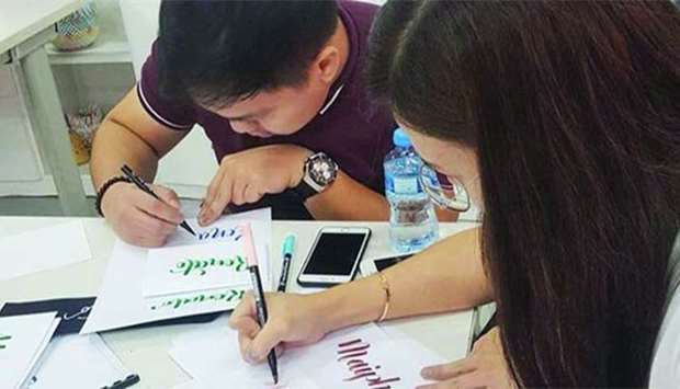 Participants try their hand at calligraphy. PICTURES: QatArt Handmade Community