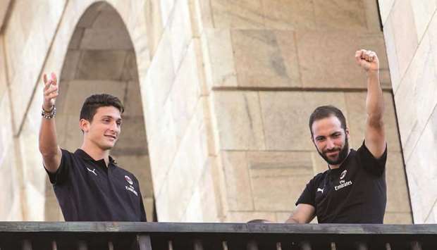 AC Milanu2019s new players Argentinian Gonzalo Higuain (R) and Italian Mattia Caldara acknowledge the fans from a balcony in Milanu2019s central Piazza Duomo square yesterday. (AFP)