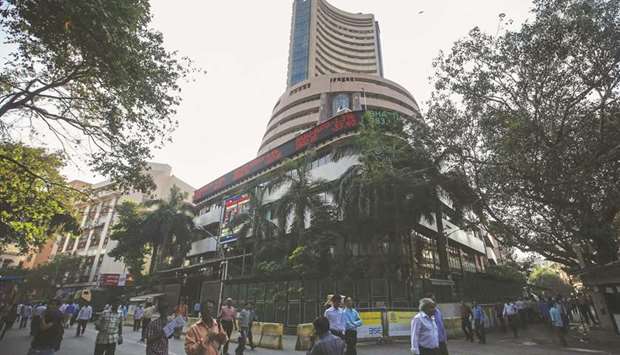 People walk by the Bombay Stock Exchange building in Mumbai. The Sensex closed up 391 points to 37,556.16 yesterday.