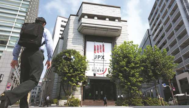 A pedestrian crosses the road in front of the Tokyo Stock Exchange. While Japanu2019s benchmark Topix index has declined more than 4% this year, it remains one of the  better-performing markets in Asia amid support from the Bank of Japanu2019s ETF purchases and as most companies continue to report robust earnings growth.