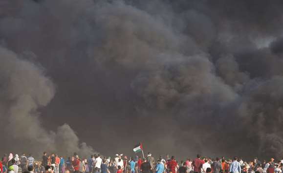 Palestinian demonstrators take part in a protest demanding the right to return to their homeland, at the Israel-Gaza border, east of Gaza City yesterday.