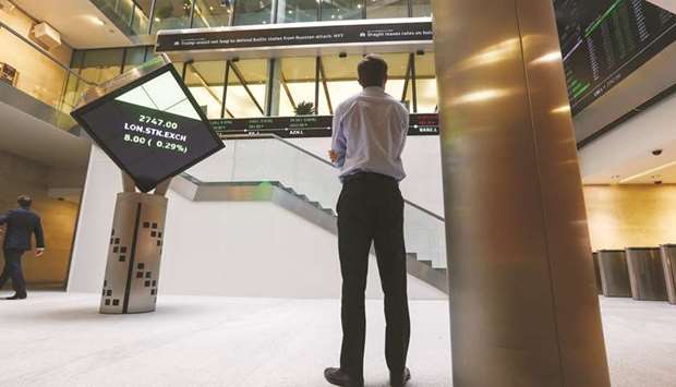 A visitor looks at a ticker of share prices in the atrium of the London Stock Exchange Group offices in Paternoster Square. The FTSE 100 closed 1.1% up at 7,659.10 points yesterday.
