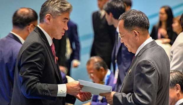 North Korea's Foreign Minister Ri Yong Ho is handed US President Donald Trump's reply to North Korean leader Kim Jong Un's letter, by a member of the US delegation at the ASEAN meeting in Singapore