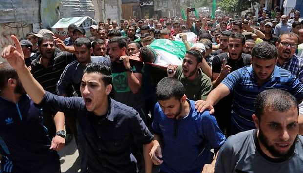Palestinian mourners carry the body of Muadh al-Suri, aged 15, who was killed in clashes with Israeli forces the day before, during his funeral in Nuseirat camp, in central Gaza Strip.