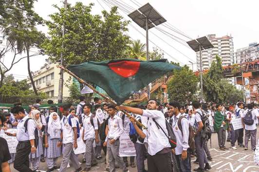 A student waves Bangladeshu2019s national flag during a protest in Dhaka yesterday.