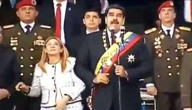 Screengrab taken from a handout video released by Venezuelan Television (VTV) showing Venezuelan President Nicolas Maduro (C), his wife Cilia Flores (L) and military authorities reacting to a loud band during a ceremony to celebrate the 81st anniversary of the National Guard yesterday in Caracas.